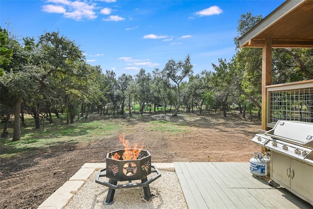 view of yard featuring a fire pit and a wooden deck