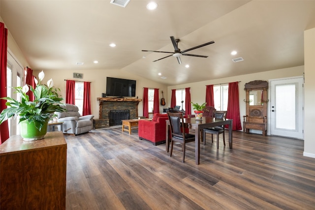 dining space with a stone fireplace, lofted ceiling, ceiling fan, and dark hardwood / wood-style flooring