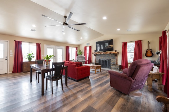 living room with lofted ceiling, a stone fireplace, dark hardwood / wood-style floors, and ceiling fan