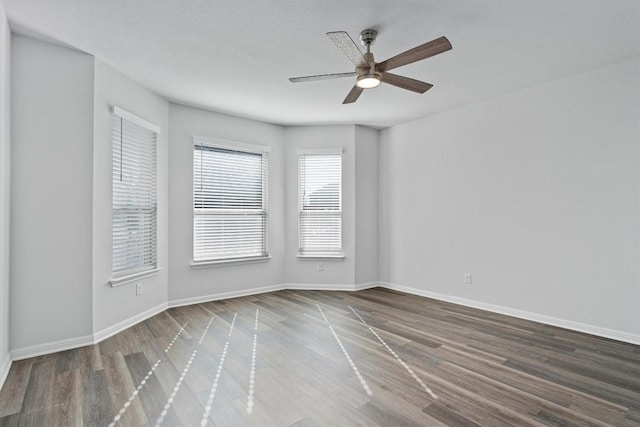 empty room featuring ceiling fan and dark wood-type flooring