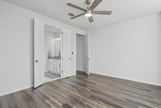 unfurnished bedroom with ceiling fan, dark hardwood / wood-style flooring, and connected bathroom