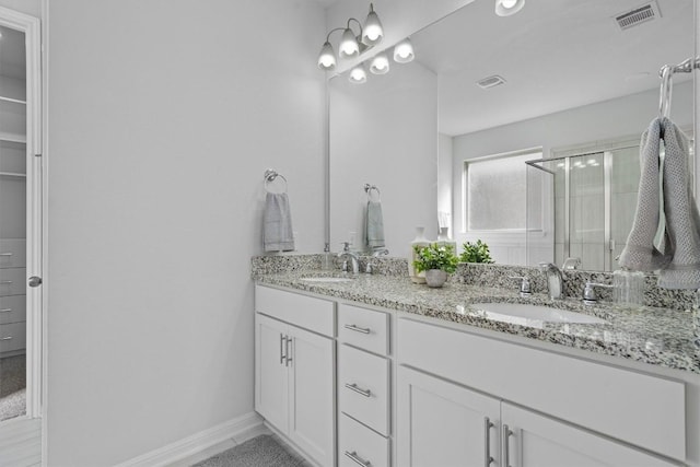 bathroom with vanity and a shower with shower door