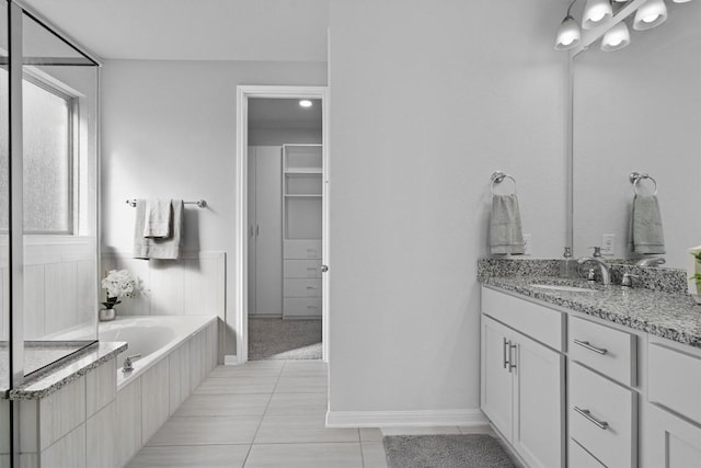 bathroom featuring vanity, tiled bath, and tile patterned floors