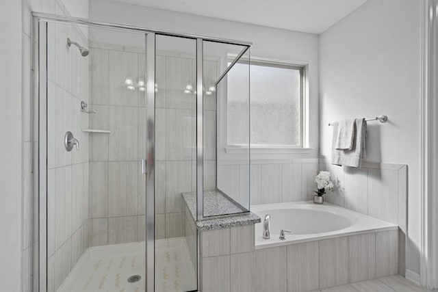 bathroom featuring separate shower and tub