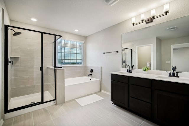 bathroom with vanity, shower with separate bathtub, a textured ceiling, and tile patterned floors