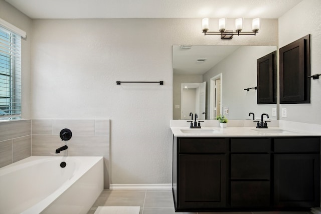 bathroom featuring vanity, a washtub, and tile patterned flooring