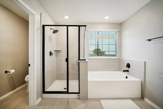 bathroom featuring toilet, plus walk in shower, and tile patterned floors