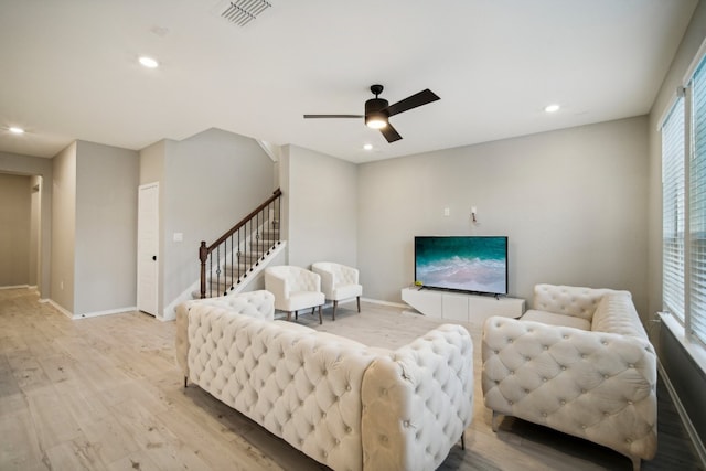 living room featuring light hardwood / wood-style flooring and ceiling fan