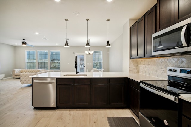 kitchen featuring a healthy amount of sunlight, stainless steel appliances, sink, and light wood-type flooring