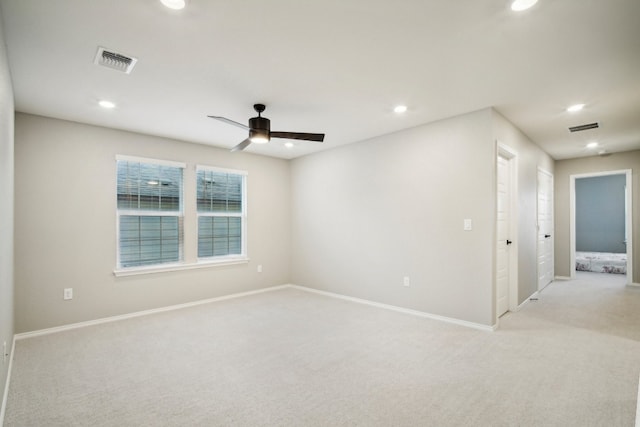 spare room featuring light carpet and ceiling fan