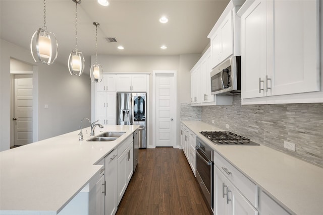 kitchen with light countertops, decorative backsplash, appliances with stainless steel finishes, dark wood-type flooring, and white cabinetry