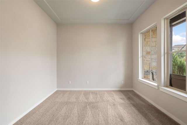 spare room featuring carpet and baseboards