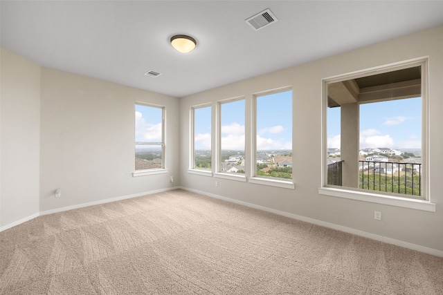 carpeted empty room featuring visible vents and baseboards