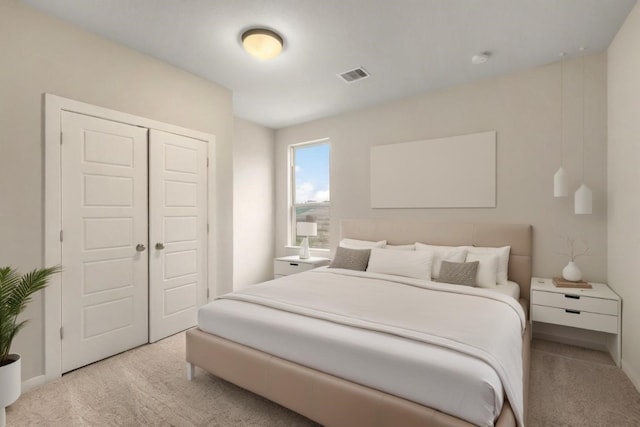 bedroom with a closet, visible vents, and carpet flooring