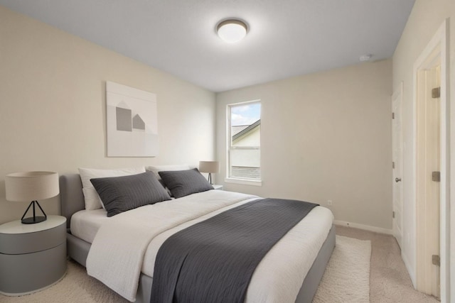 bedroom featuring light carpet and baseboards