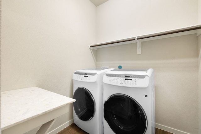 laundry room with laundry area, washing machine and dryer, baseboards, and dark wood-type flooring