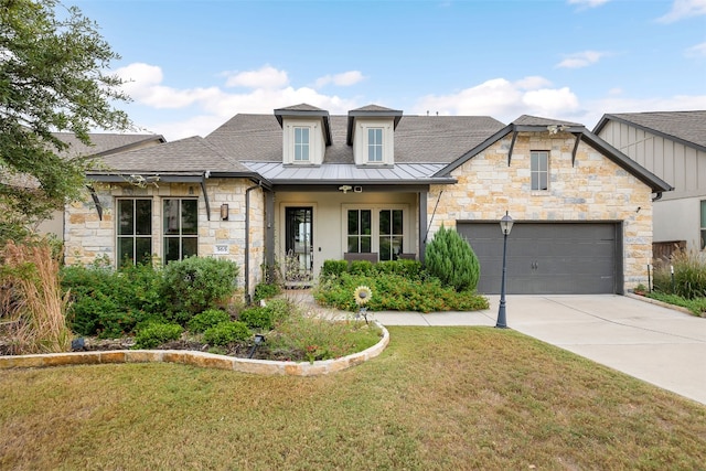 view of front of home with metal roof, an attached garage, concrete driveway, a standing seam roof, and a front yard