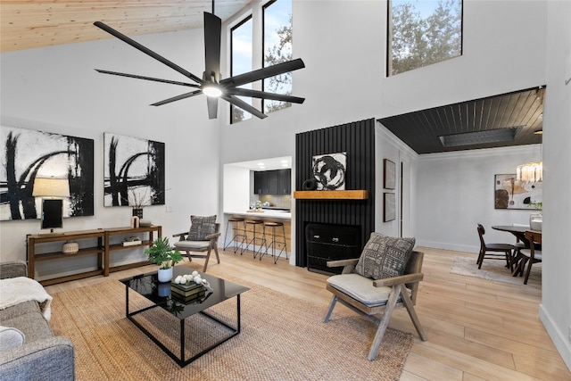 living room with high vaulted ceiling, ceiling fan, wooden ceiling, and light hardwood / wood-style floors