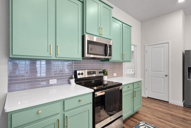 kitchen with backsplash, green cabinets, dark hardwood / wood-style floors, and appliances with stainless steel finishes