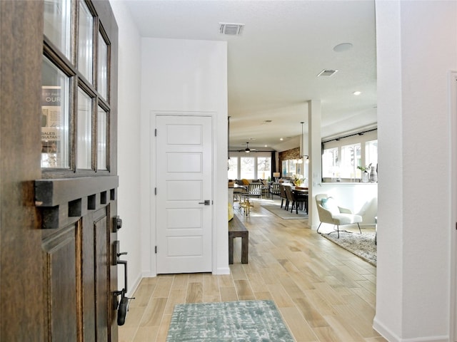 entrance foyer with a fireplace, light hardwood / wood-style floors, and ceiling fan