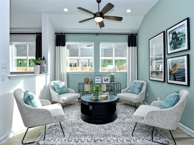 sitting room featuring ceiling fan, light wood-type flooring, and vaulted ceiling