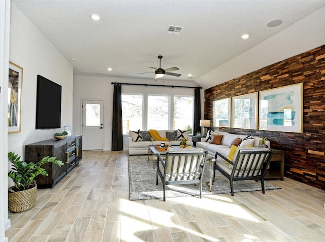 living room featuring ceiling fan, light wood-type flooring, and vaulted ceiling