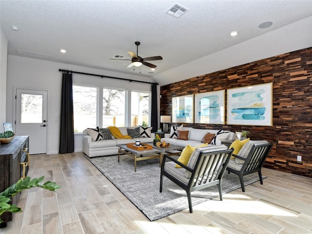 living room featuring ceiling fan, a textured ceiling, and light hardwood / wood-style flooring