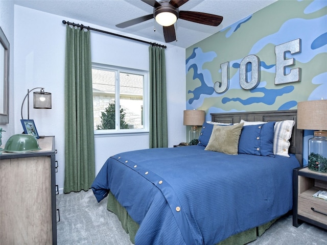 carpeted bedroom featuring ceiling fan and a textured ceiling