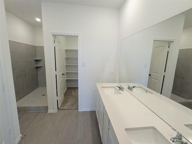 903 Bobby Lou Ln, Copperas Cove, TX 76522 - bathroom featuring wood finished floors, a tile shower, and double vanity