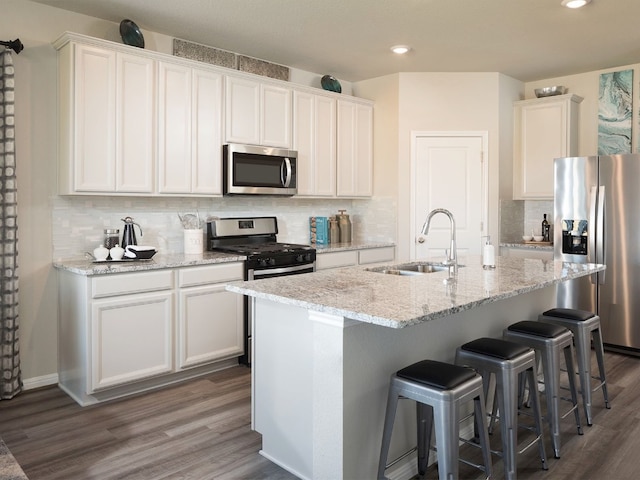 kitchen featuring white cabinets, sink, a kitchen island with sink, and appliances with stainless steel finishes