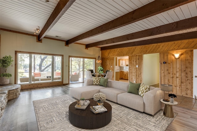 living room with wooden walls, hardwood / wood-style floors, wooden ceiling, and beam ceiling