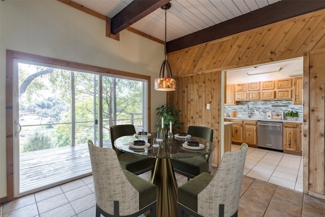 tiled dining space with wood walls, wooden ceiling, and beam ceiling