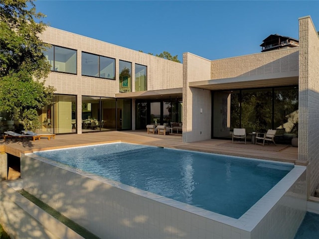 outdoor pool with a patio area and outdoor lounge area