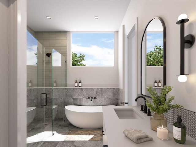 bathroom with independent shower and bath, sink, a healthy amount of sunlight, and tile walls