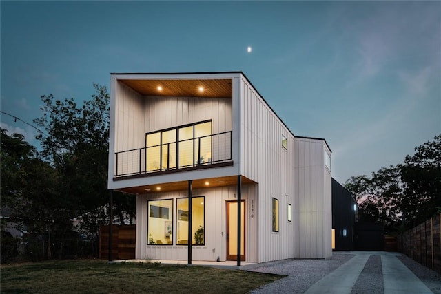 back house at dusk with a balcony