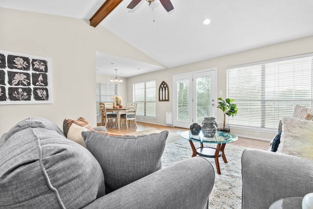 living room featuring ceiling fan with notable chandelier and vaulted ceiling with beams