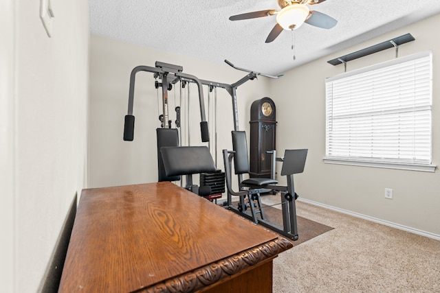 carpeted office with a textured ceiling and ceiling fan