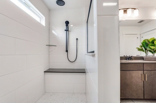 bathroom with a shower and vanity