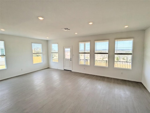 unfurnished room with recessed lighting, visible vents, baseboards, and dark wood-type flooring