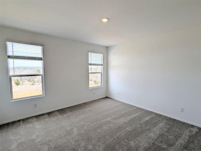 carpeted empty room featuring baseboards