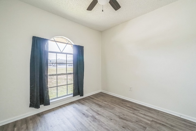 empty room with hardwood / wood-style flooring, ceiling fan, and a textured ceiling