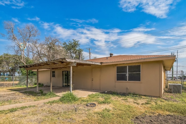 back of property featuring central AC unit, a patio, and a lawn