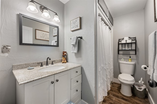 bathroom with hardwood / wood-style floors, vanity, and toilet