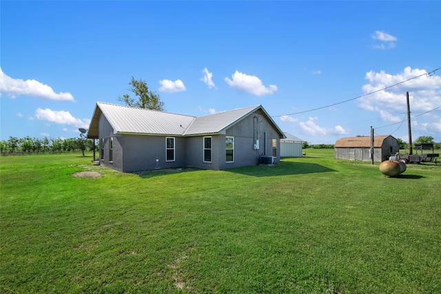 rear view of property with an outbuilding and a yard