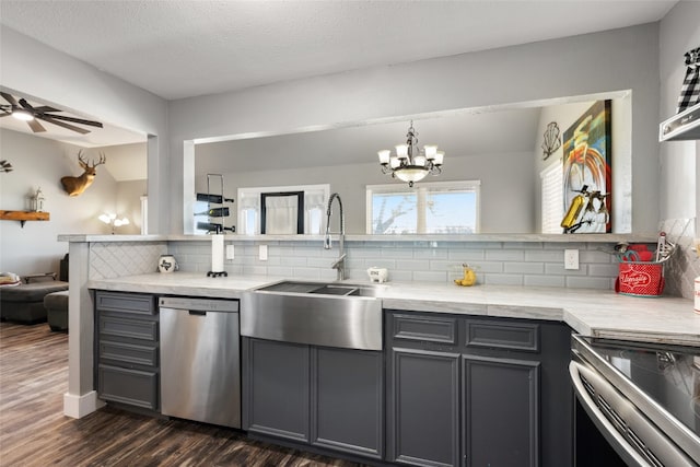 kitchen featuring gray cabinetry, dark wood-type flooring, sink, decorative backsplash, and appliances with stainless steel finishes