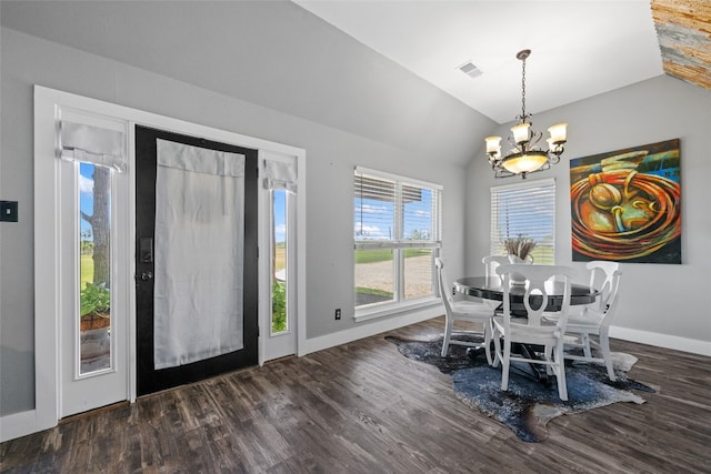 dining space with dark hardwood / wood-style flooring, an inviting chandelier, and vaulted ceiling