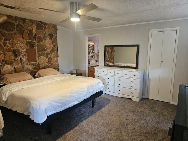 bedroom featuring ceiling fan, ensuite bathroom, a textured ceiling, carpet, and ornamental molding