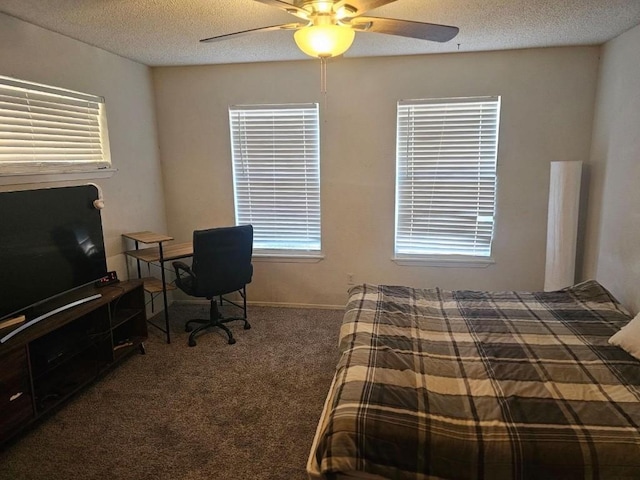 bedroom featuring dark colored carpet, a textured ceiling, and ceiling fan