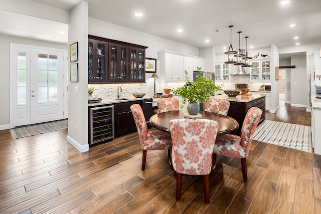 dining space with dark wood-type flooring, beverage cooler, and sink