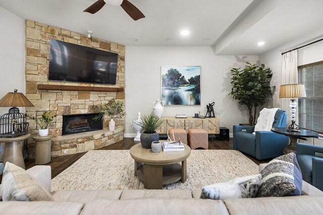 living room featuring ceiling fan, a fireplace, and wood-type flooring